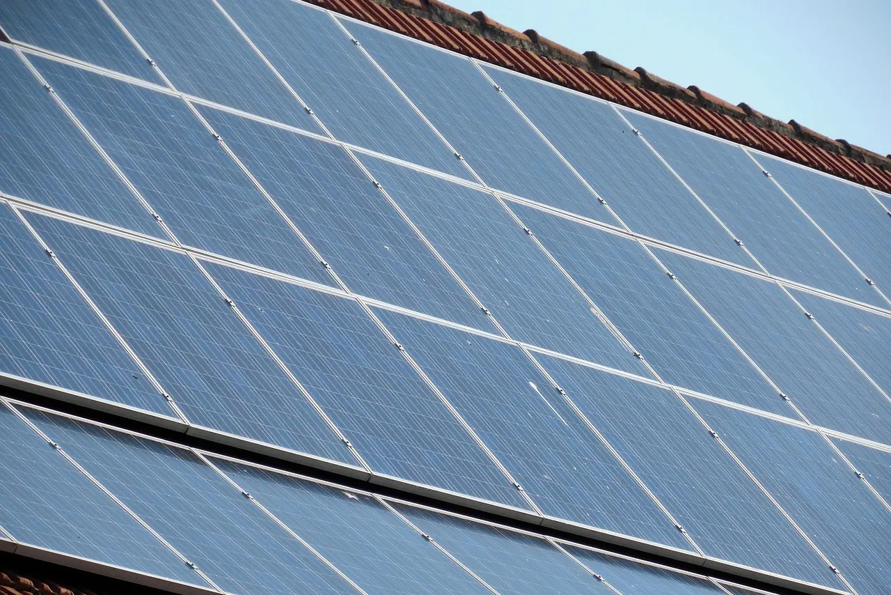 Reihen blauer Solarmodule auf einem Ziegeldach, schräg von unten gegen den Himmel fotografiert (Göda, Landkreis Bautzen)