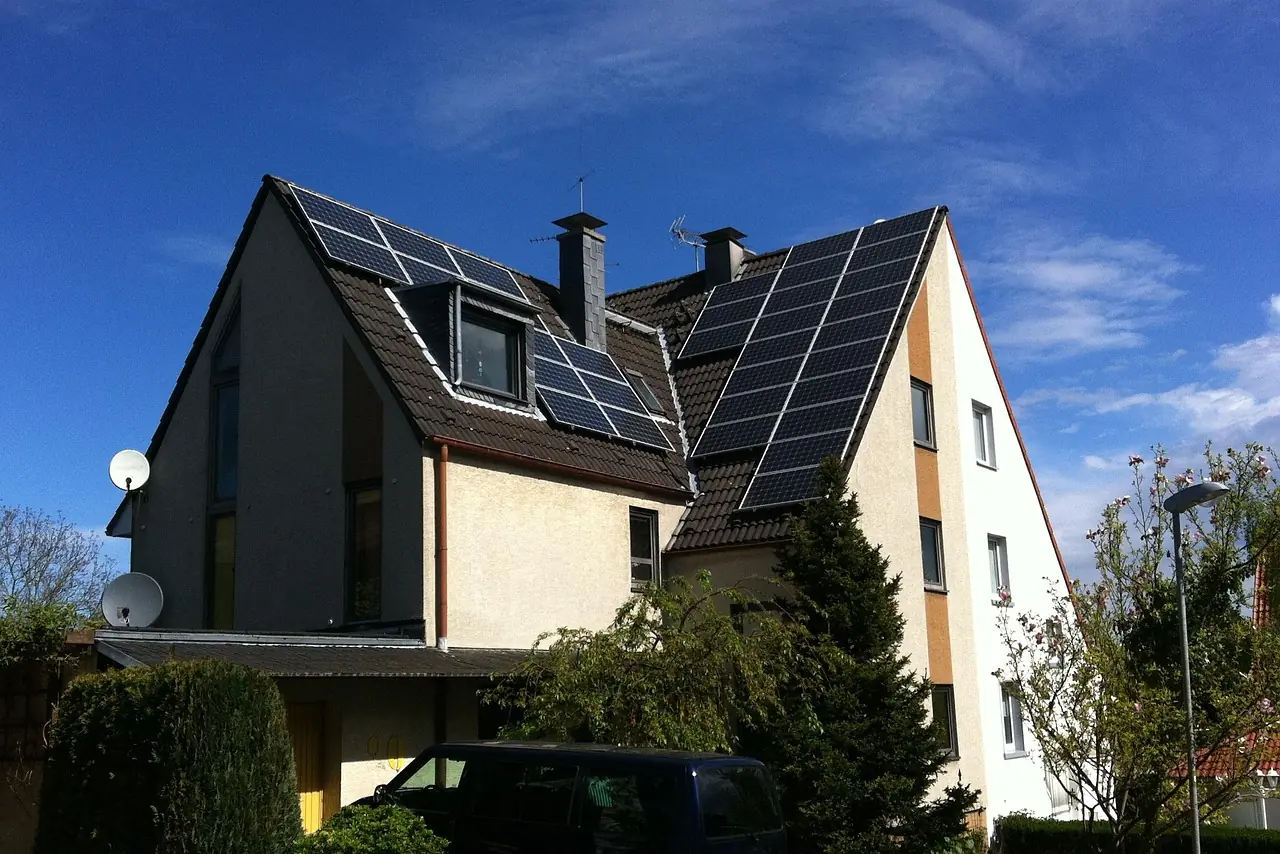Einfamilienhaus mit zwei Giebeln und Solarmodulen auf beiden Dachflächen unter blauem Himmel (Barntrup, Kreis Lippe)