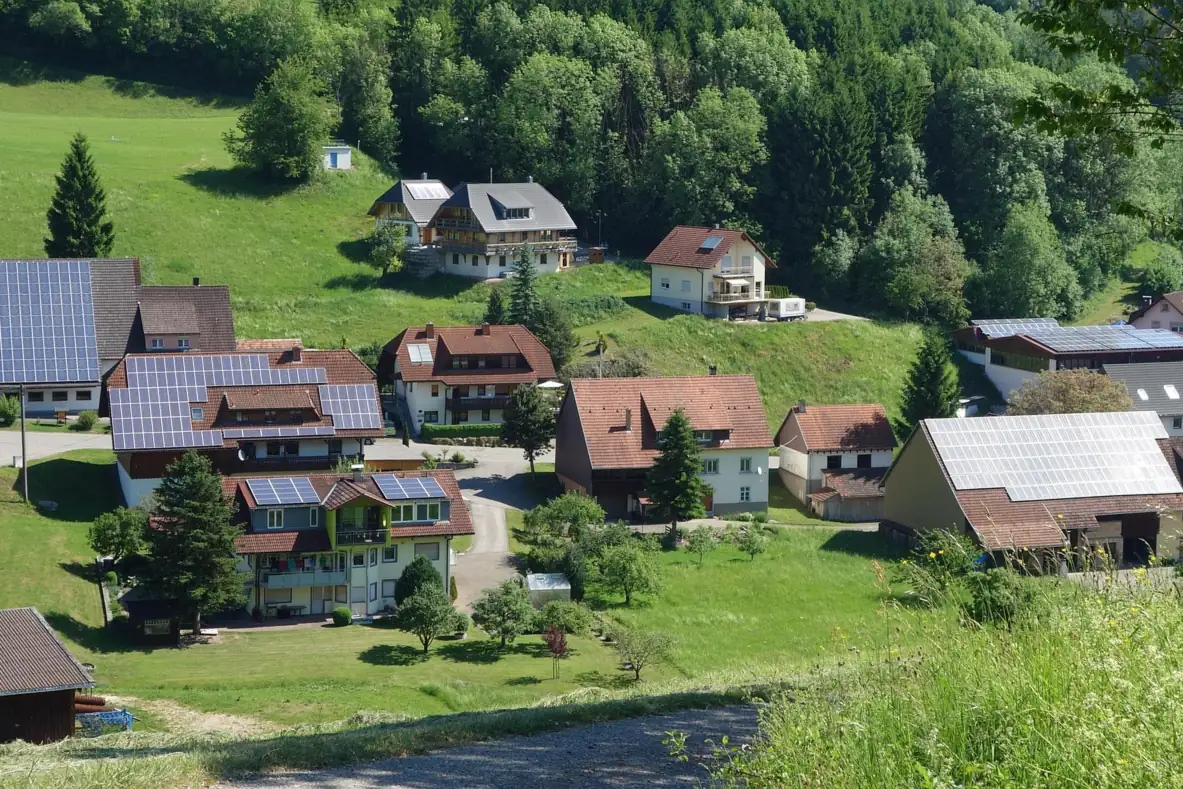 Dorf an einem grünen Hang mit Solarmodulen auf mehreren Wohnhäusern und Scheunen (Assmannshausen, Rheingau-Taunus-Kreis)