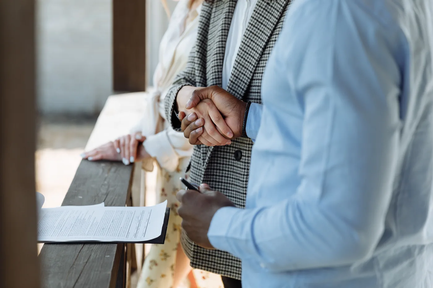 Händedruck zweier Personen, daneben liegen Unterlagen auf einer hölzernen Ablage (Meuselwitz, Altenburger Land)